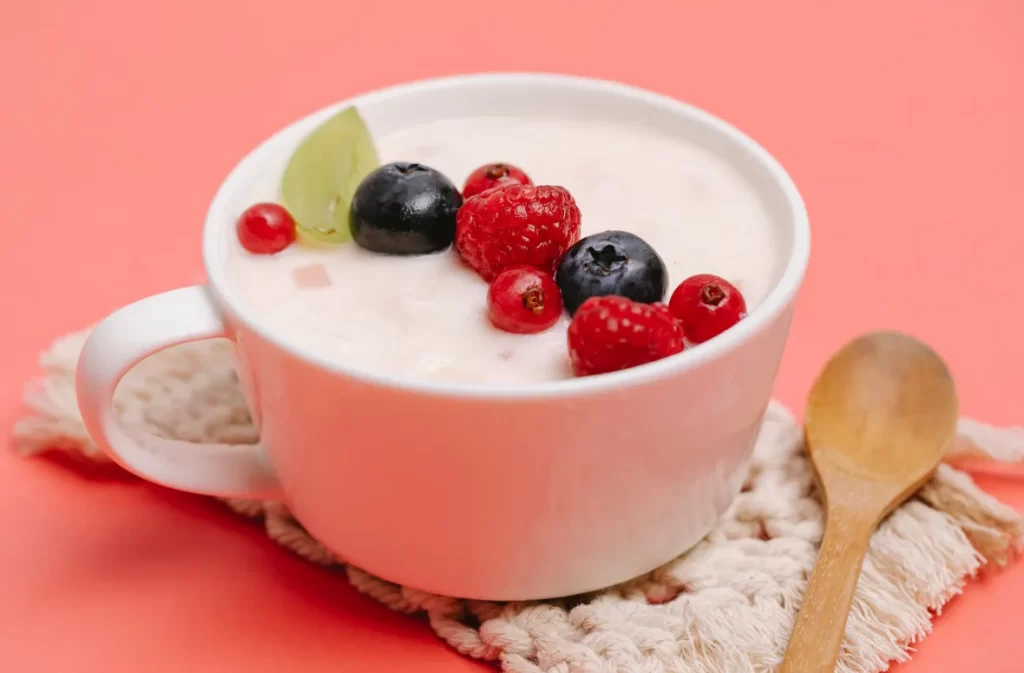 A smooth and creamy cocoa fruit cup in a white mug, topped with fresh berries for a refreshing twist.